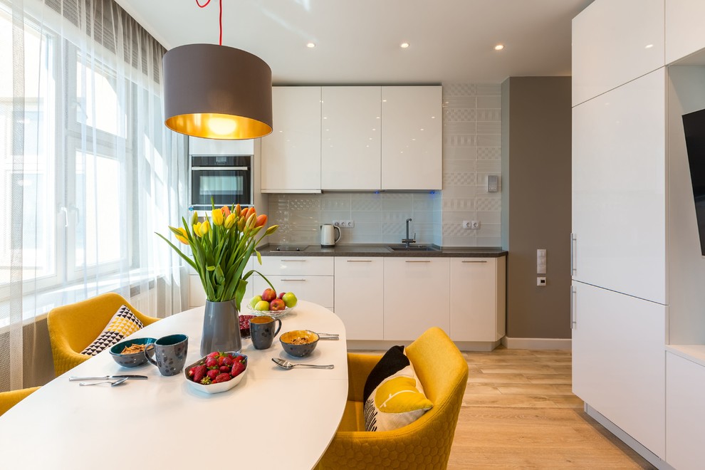 Свежая идея для дизайна: кухня-столовая в современном стиле с серыми стенами, светлым паркетным полом и бежевым полом - отличное фото интерьера