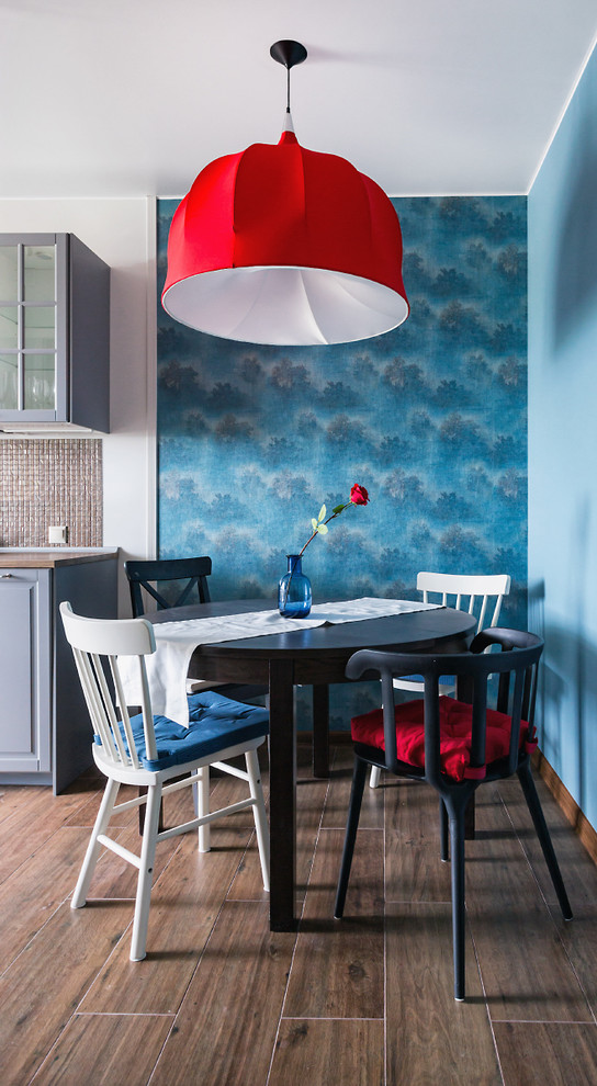 Пример оригинального дизайна: кухня-столовая в стиле фьюжн с синими стенами и темным паркетным полом