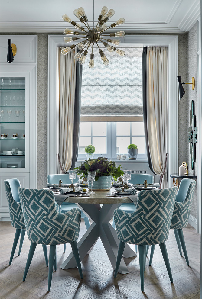 Immagine di una sala da pranzo aperta verso la cucina classica con pareti grigie e parquet chiaro