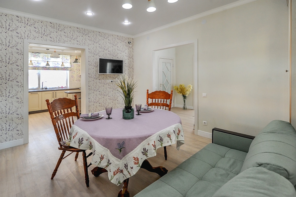 Esempio di una sala da pranzo aperta verso la cucina country di medie dimensioni con pareti bianche, pavimento in vinile, pavimento beige e carta da parati