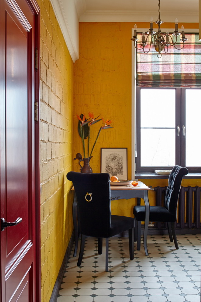 На фото: кухня-столовая среднего размера в стиле фьюжн с желтыми стенами без камина