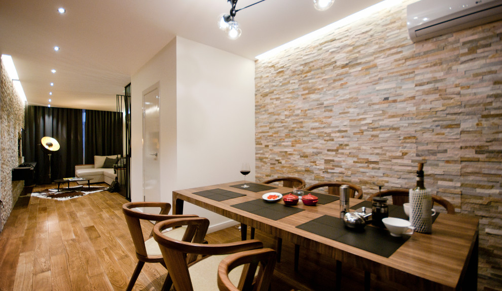 Aménagement d'une petite salle à manger contemporaine avec un mur blanc et un sol en bois brun.