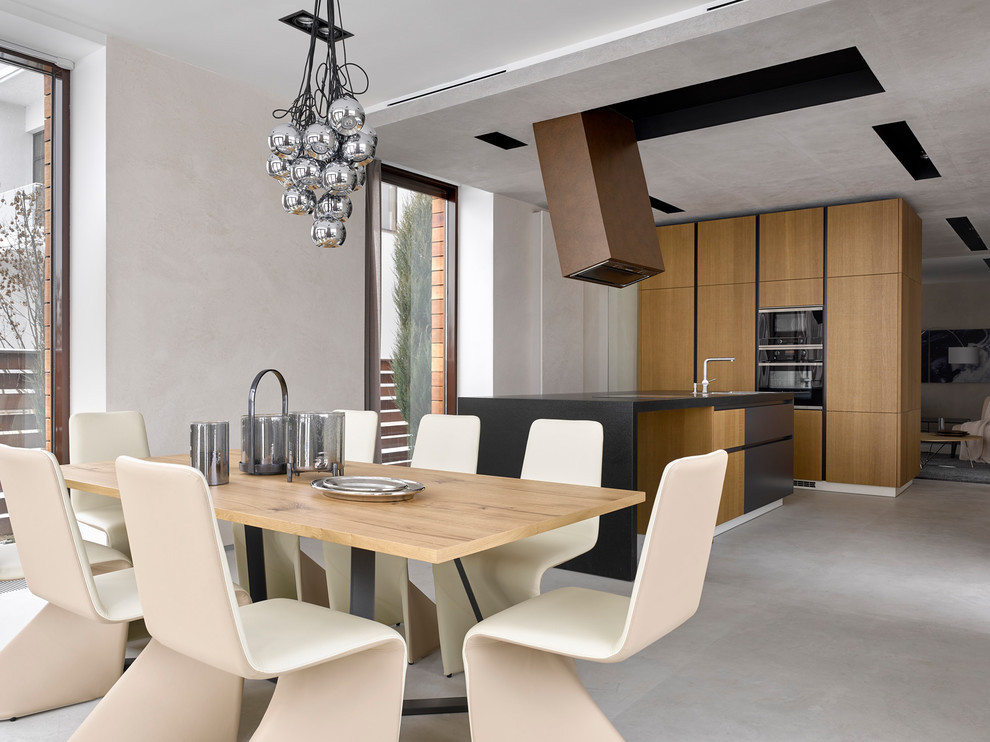 Foto di una sala da pranzo aperta verso la cucina contemporanea con pavimento grigio e pareti beige