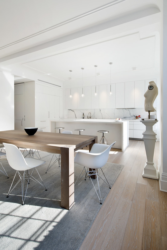 Immagine di una sala da pranzo aperta verso la cucina scandinava con parquet chiaro