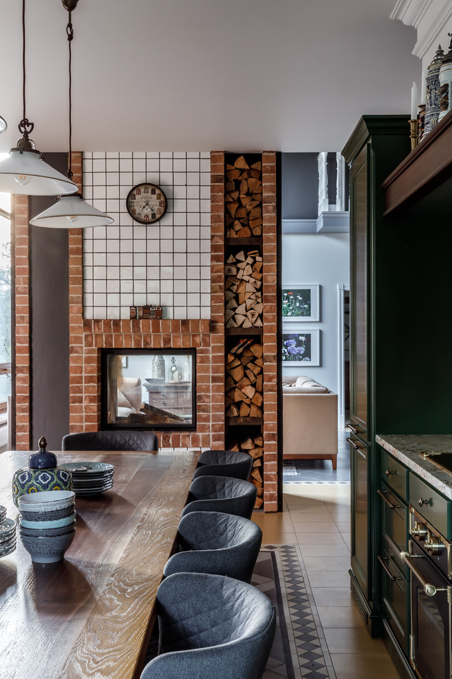 Mediterrane Wohnküche mit grauer Wandfarbe, Tunnelkamin und Kaminumrandung aus Backstein in Sonstige