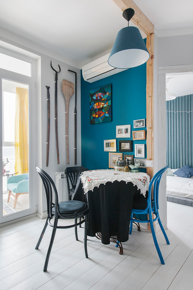 Idee per una sala da pranzo aperta verso il soggiorno boho chic con pareti blu, pavimento in legno verniciato e pavimento bianco