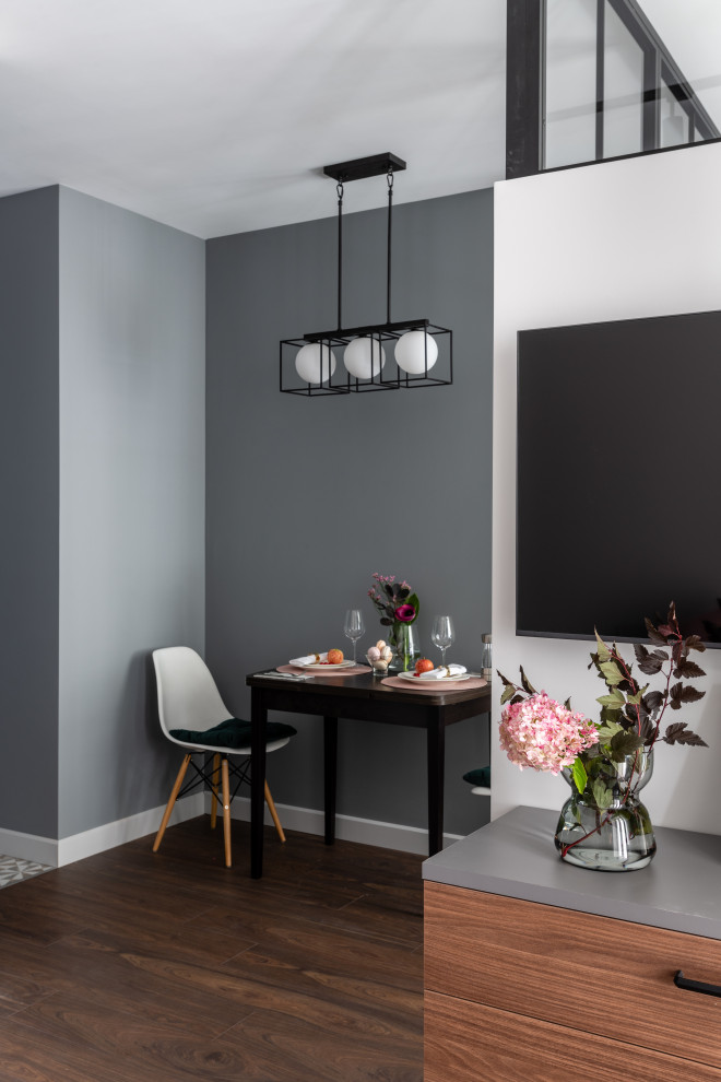 Inspiration pour une petite salle à manger ouverte sur la cuisine design avec un mur gris, sol en stratifié et un sol marron.