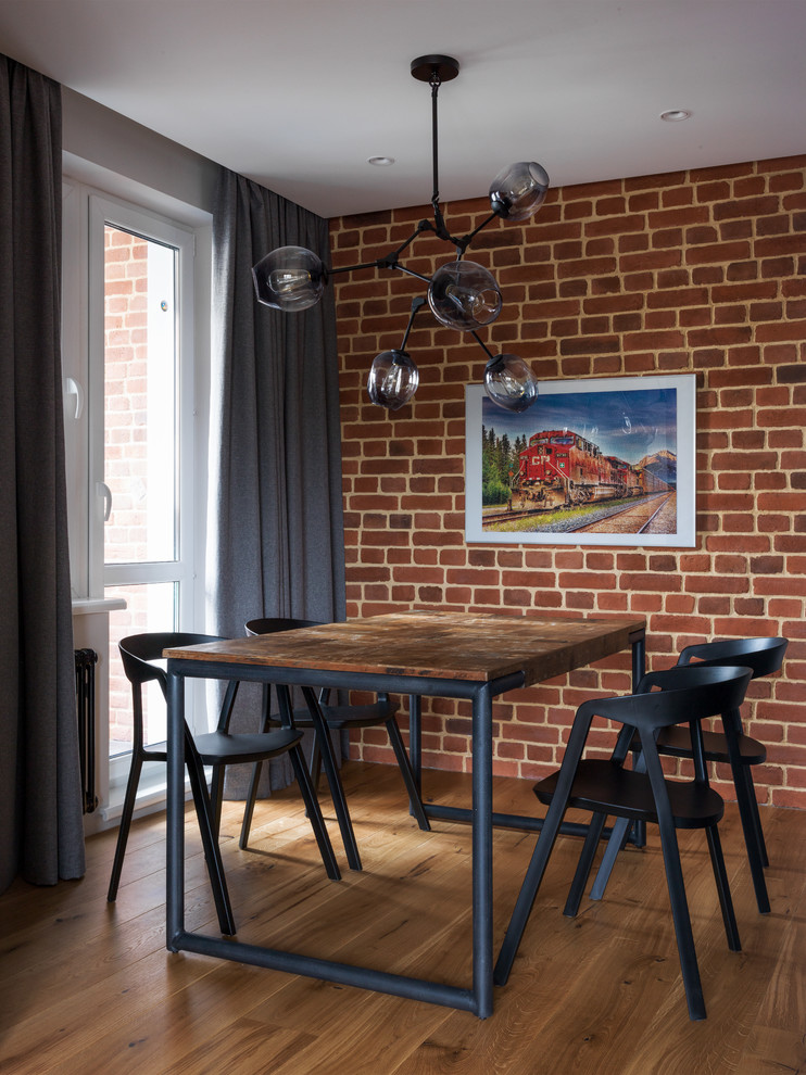 Ejemplo de comedor urbano con suelo de madera en tonos medios y paredes rojas