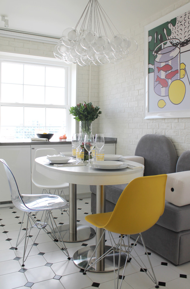 Aménagement d'une salle à manger ouverte sur la cuisine contemporaine avec un mur blanc et un sol multicolore.