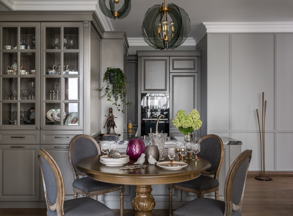 Cette image montre une salle à manger ouverte sur le salon traditionnelle avec un mur gris, un sol en bois brun et un sol marron.