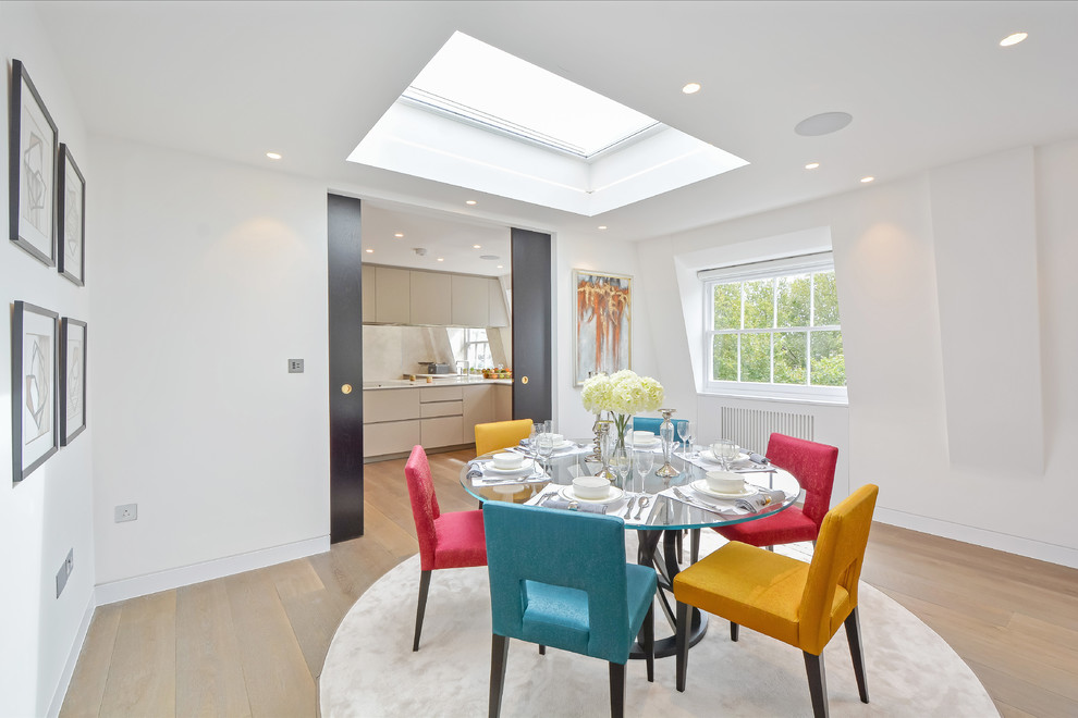 This is an example of a small contemporary dining room in London with white walls, light hardwood flooring and beige floors.