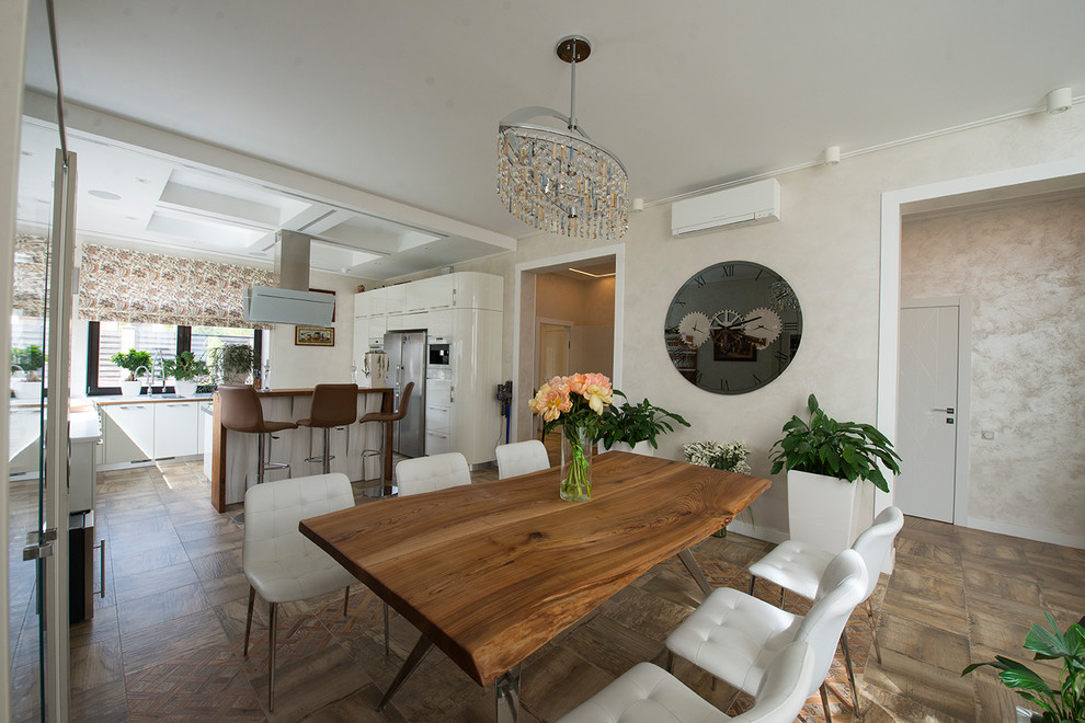 На фото: большая гостиная-столовая в современном стиле с белыми стенами, полом из керамогранита и коричневым полом с
