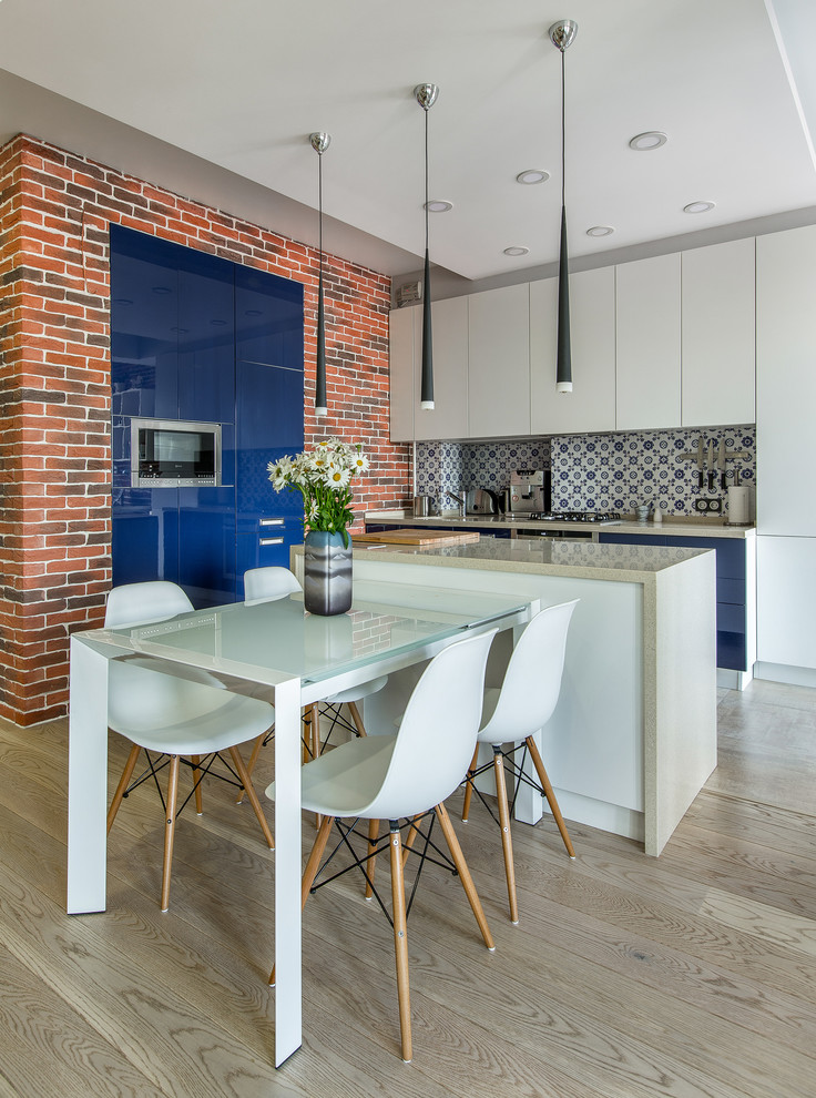Cette image montre une salle à manger ouverte sur la cuisine design avec parquet clair.