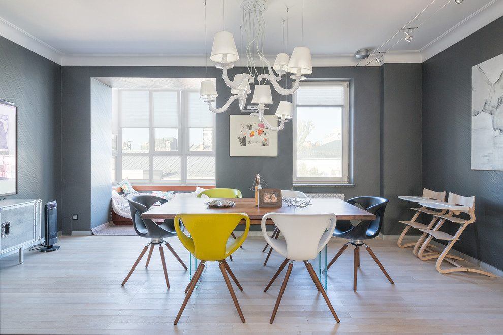 Immagine di una sala da pranzo aperta verso il soggiorno design con pareti grigie e parquet chiaro