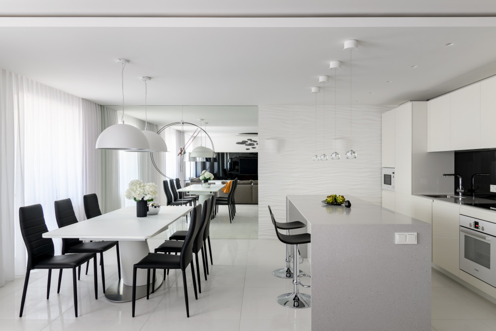 Стильный дизайн: большая кухня-столовая в современном стиле с белыми стенами и белым полом - последний тренд