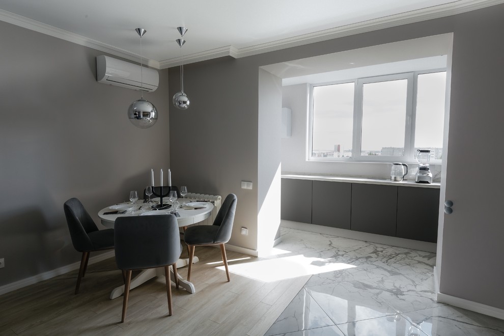 Cette photo montre une salle à manger ouverte sur la cuisine tendance de taille moyenne avec un mur gris, un sol en carrelage de porcelaine et un sol gris.