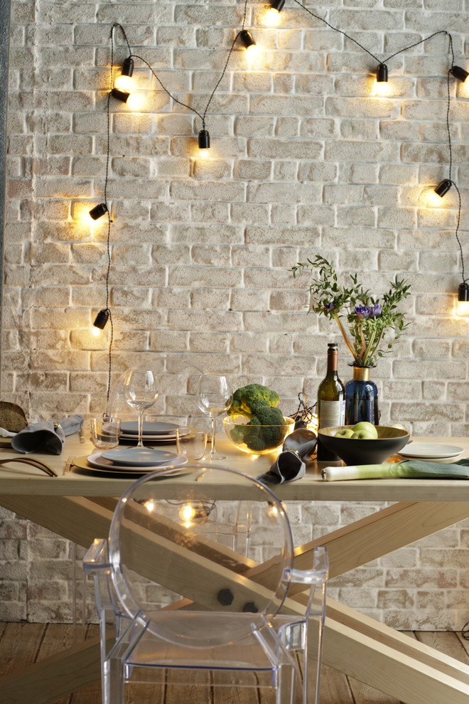 На фото: маленькая кухня-столовая в стиле лофт с белыми стенами и деревянным полом для на участке и в саду с