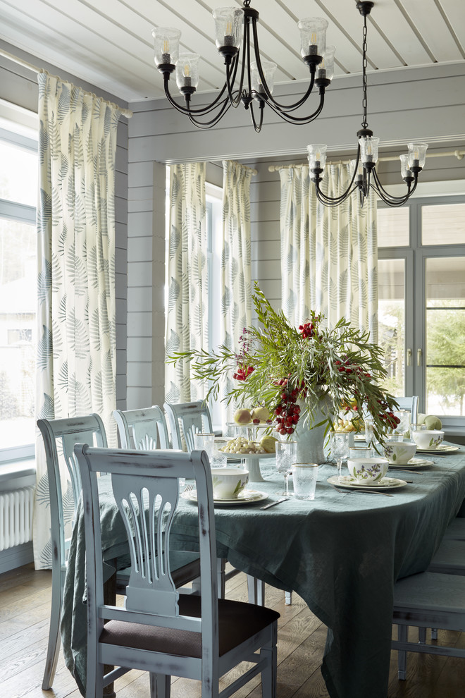 Immagine di una sala da pranzo aperta verso la cucina country di medie dimensioni con pareti grigie, parquet scuro e pavimento marrone