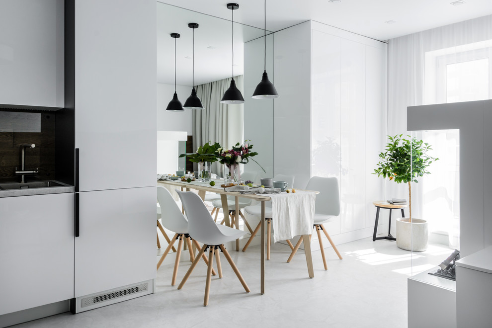 Aménagement d'une petite salle à manger ouverte sur la cuisine contemporaine avec un mur blanc, un sol en vinyl, une cheminée ribbon, un manteau de cheminée en plâtre et un sol blanc.