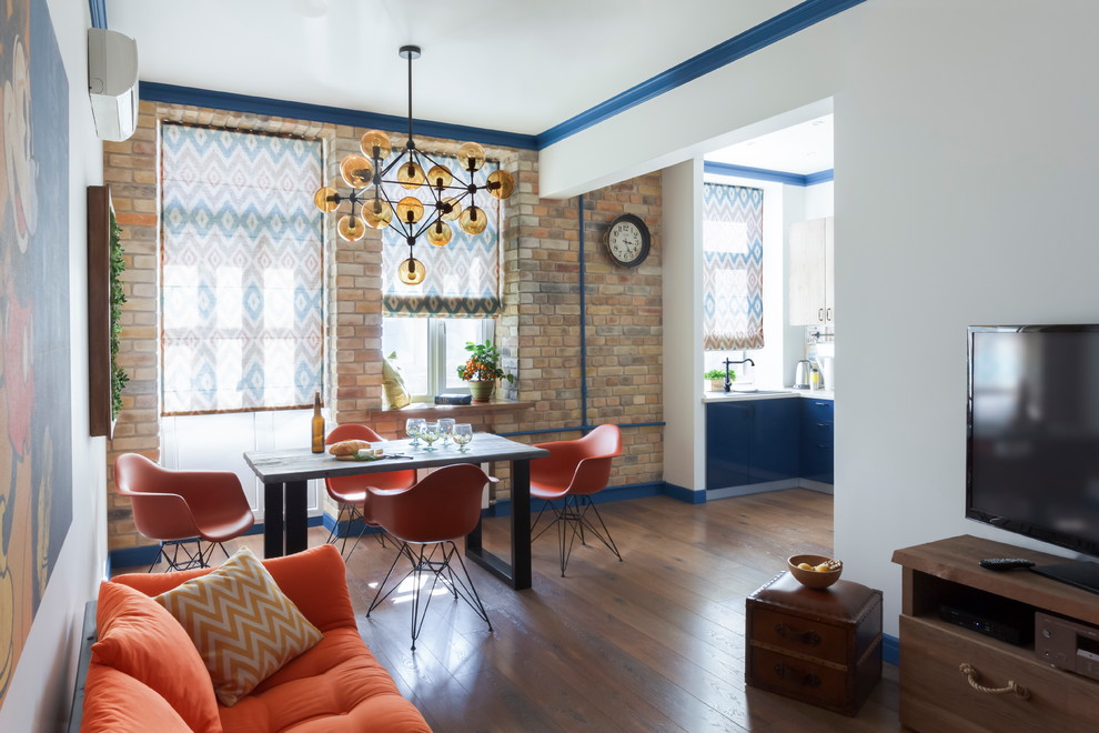 Idée de décoration pour une salle à manger ouverte sur le salon bohème de taille moyenne avec un mur blanc et un sol en bois brun.