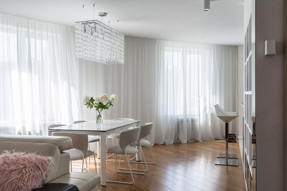Стильный дизайн: столовая в современном стиле с белыми стенами, паркетным полом среднего тона и коричневым полом - последний тренд