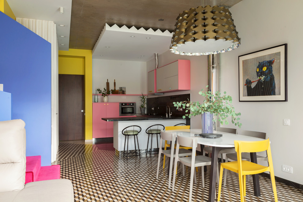 Foto di una sala da pranzo aperta verso il soggiorno bohémian con pareti bianche, pavimento multicolore e pavimento in gres porcellanato