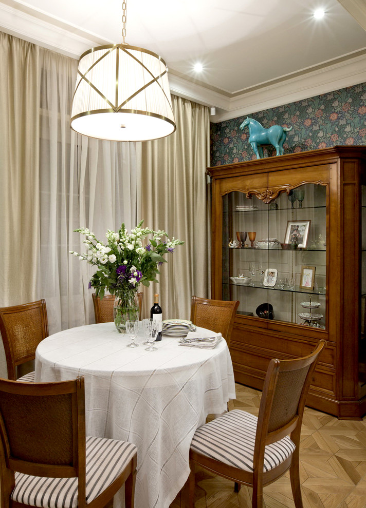 This is an example of a traditional open plan dining room in Moscow with light hardwood flooring.