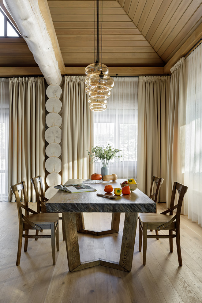 Immagine di una grande sala da pranzo aperta verso la cucina stile rurale con pavimento in legno massello medio, nessun camino e pavimento beige