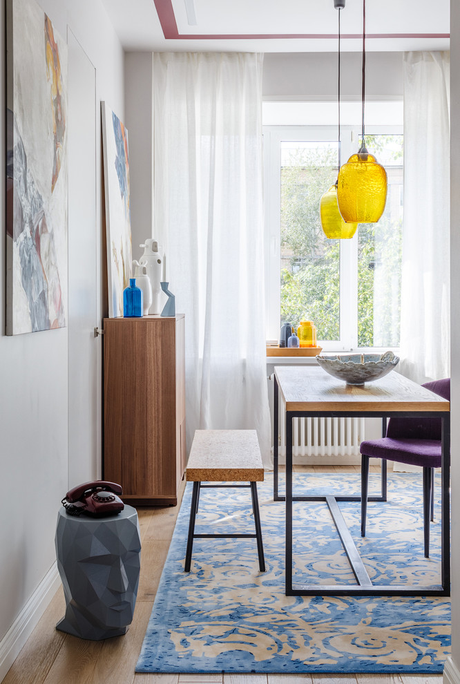На фото: столовая в скандинавском стиле с белыми стенами, паркетным полом среднего тона и коричневым полом с
