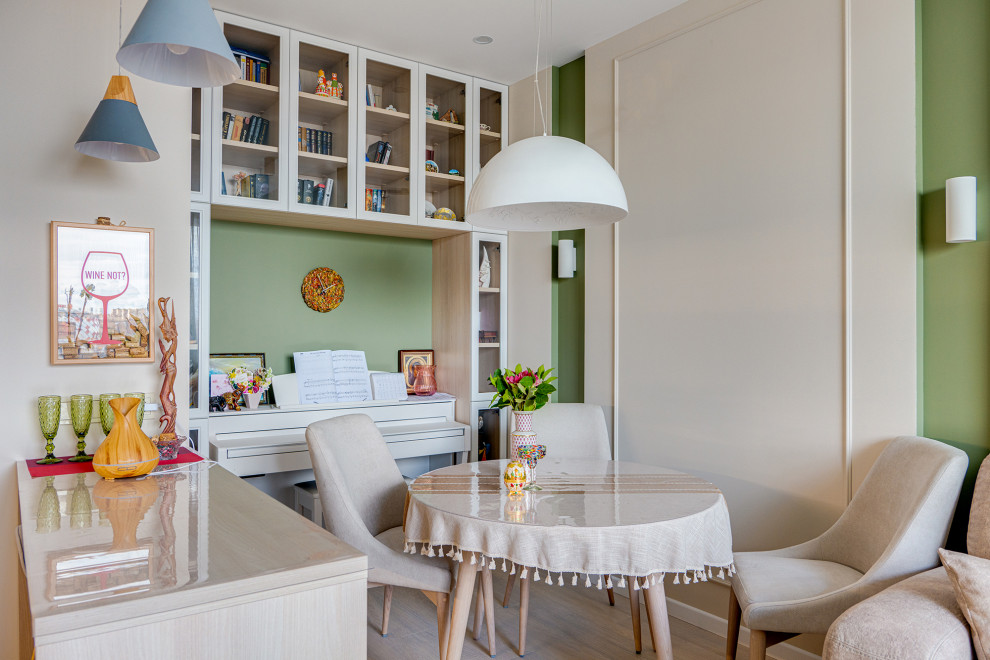 Стильный дизайн: гостиная-столовая в современном стиле с зелеными стенами и светлым паркетным полом - последний тренд