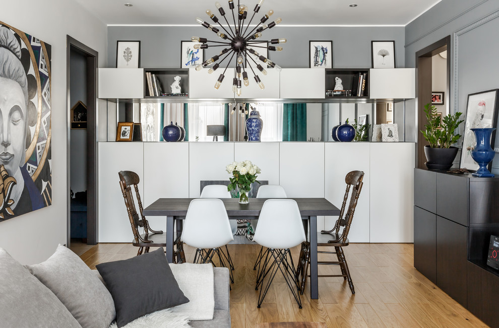 Inspiration pour une salle à manger ouverte sur le salon design avec un mur gris, un sol en bois brun et un sol marron.