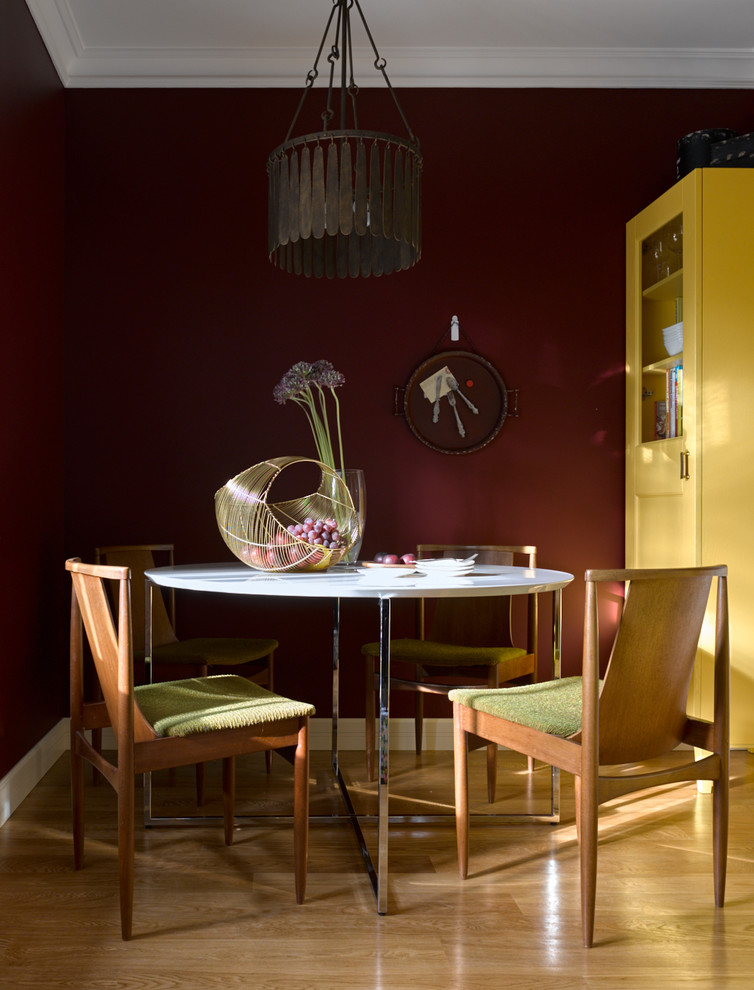 Пример оригинального дизайна: столовая в стиле неоклассика (современная классика) с красными стенами и паркетным полом среднего тона без камина