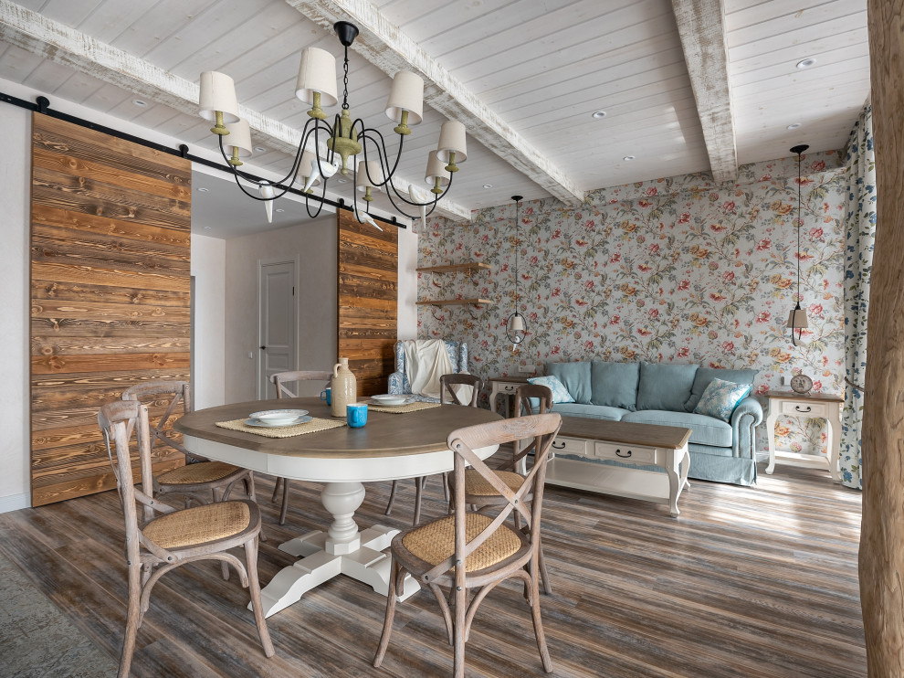 Immagine di una sala da pranzo aperta verso il soggiorno shabby-chic style di medie dimensioni con pareti multicolore, pavimento in legno verniciato, pavimento marrone, soffitto in legno e carta da parati