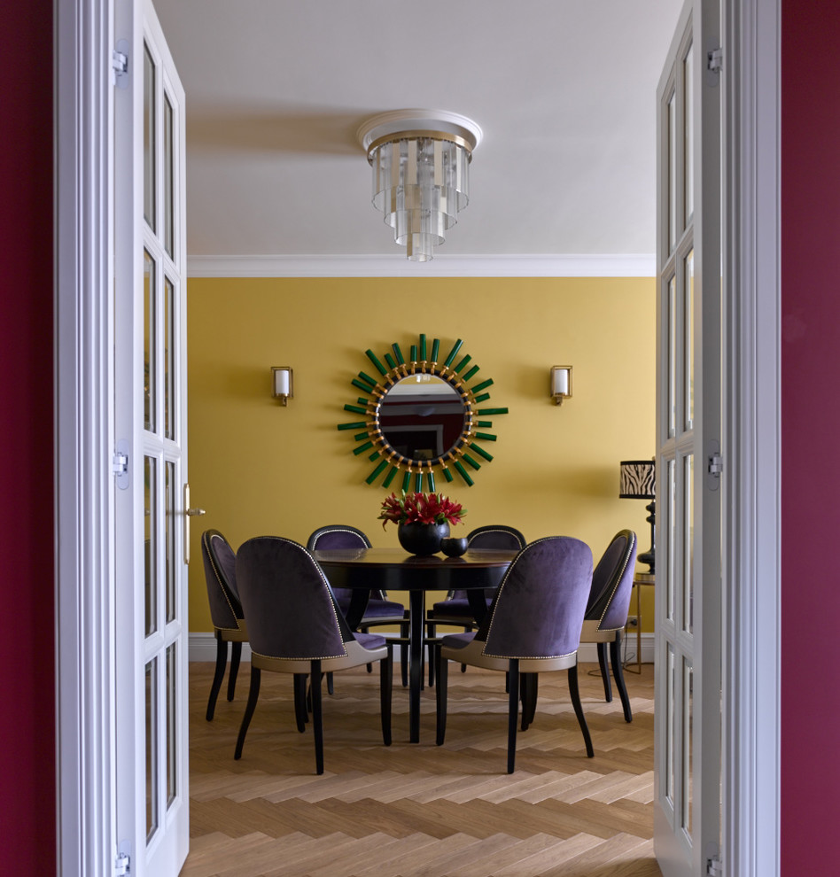 Foto di una sala da pranzo eclettica con pareti gialle e pavimento in legno massello medio