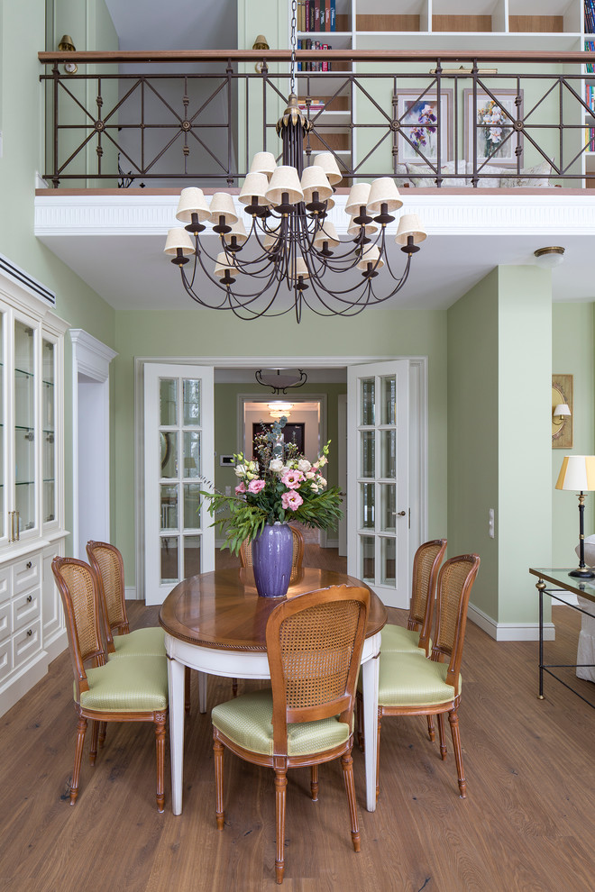 На фото: гостиная-столовая в классическом стиле с зелеными стенами и паркетным полом среднего тона с