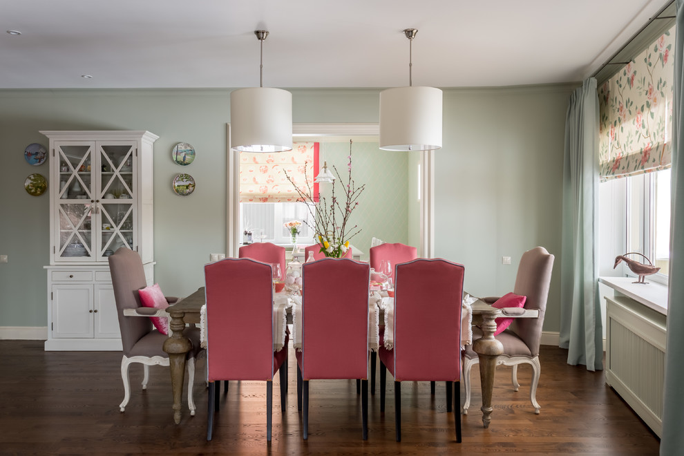 Cette image montre une salle à manger traditionnelle avec un mur vert et parquet foncé.
