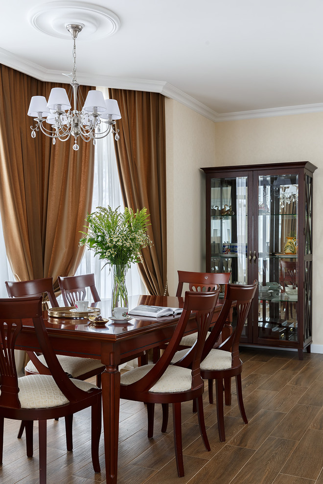 Aménagement d'une salle à manger ouverte sur le salon classique de taille moyenne avec un mur beige, un sol marron, une cheminée standard et un manteau de cheminée en pierre.