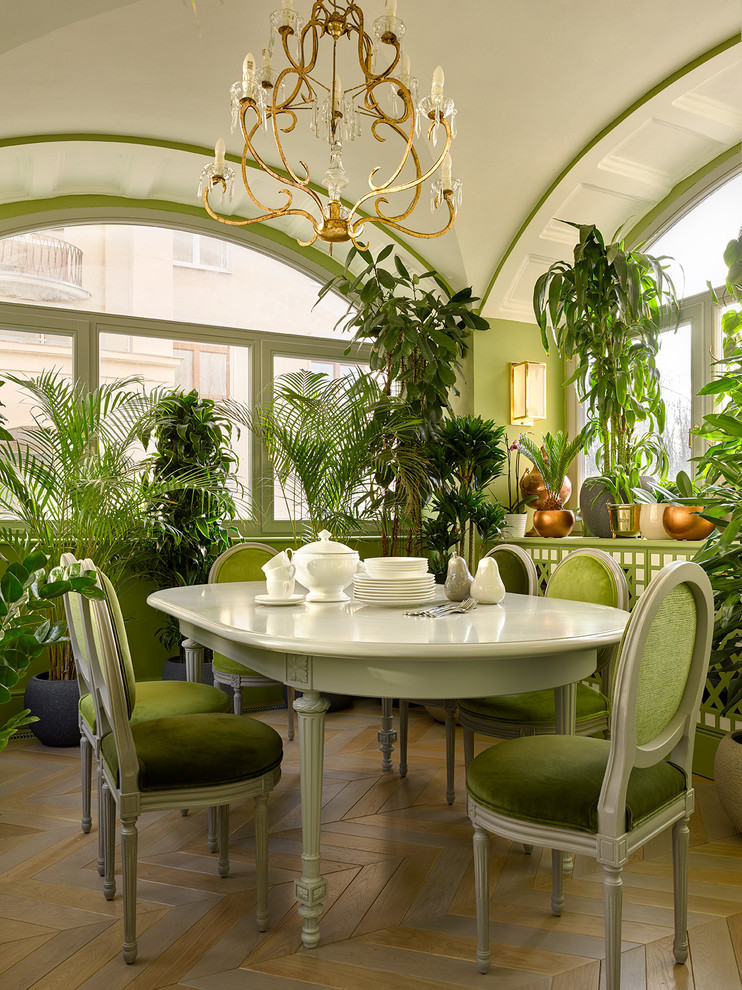 На фото: столовая в стиле неоклассика (современная классика) с зелеными стенами, паркетным полом среднего тона и разноцветным полом