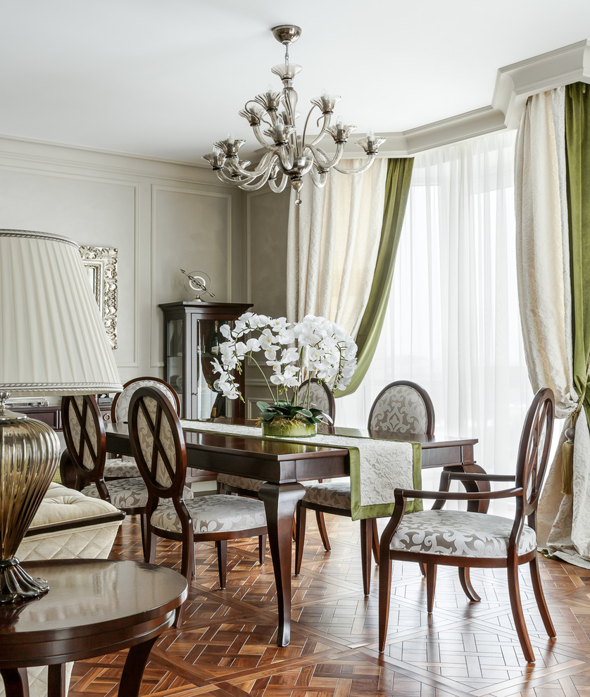 Стильный дизайн: гостиная-столовая в классическом стиле с серыми стенами, паркетным полом среднего тона и коричневым полом - последний тренд