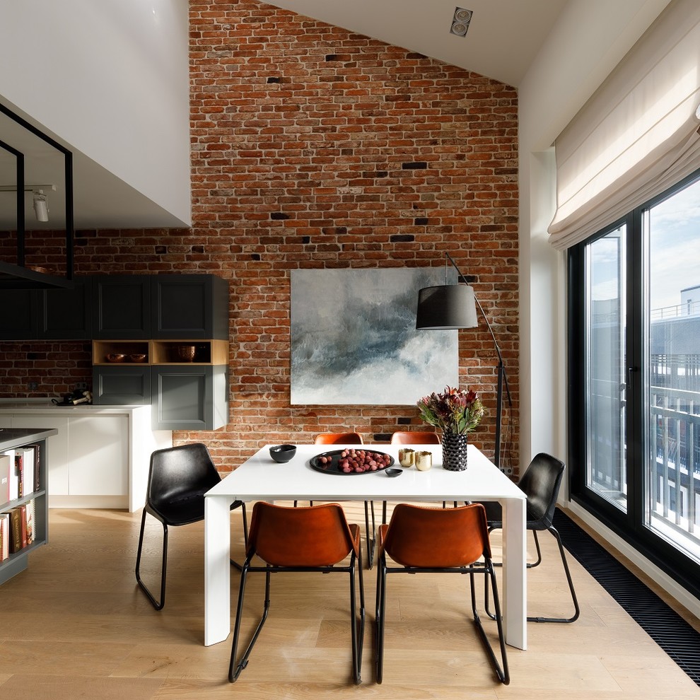 Esempio di una sala da pranzo aperta verso il soggiorno industriale con pareti marroni, parquet chiaro e pavimento beige