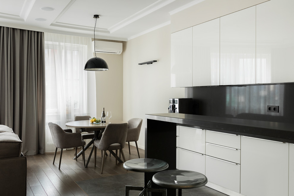 Immagine di una sala da pranzo aperta verso il soggiorno minimal con pareti bianche, parquet scuro e pavimento marrone