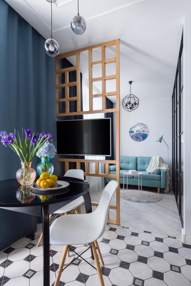 На фото: маленькая гостиная-столовая в современном стиле с белыми стенами и разноцветным полом для на участке и в саду