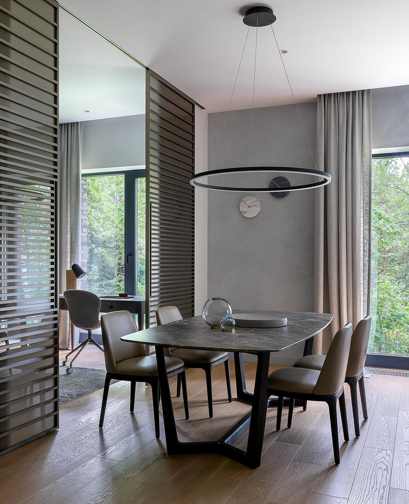Esempio di una sala da pranzo contemporanea con pareti grigie, parquet chiaro e pavimento beige