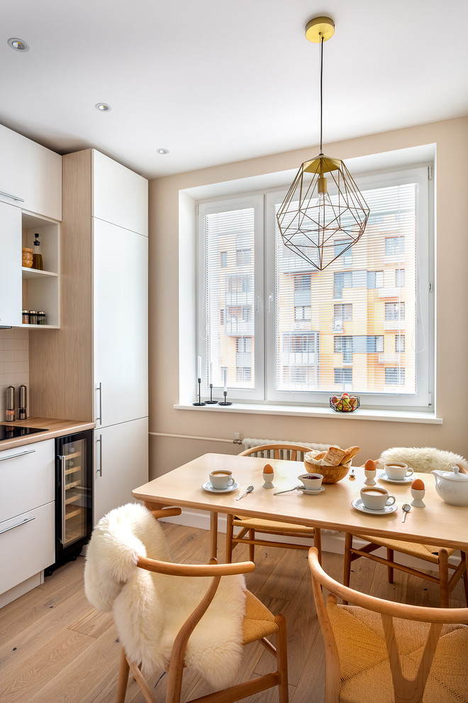 Ejemplo de comedor de cocina nórdico pequeño con suelo de madera clara, suelo beige y paredes beige