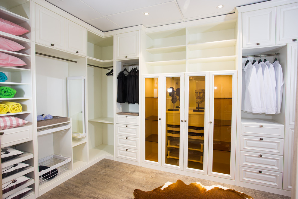 This is an example of a large traditional gender-neutral dressing room in Melbourne with raised-panel cabinets, white cabinets, plywood floors and brown floor.
