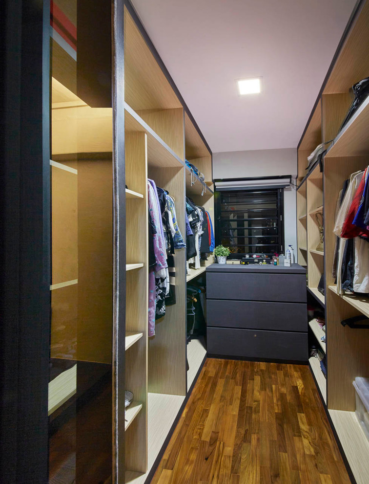 Bild på ett litet funkis walk-in-closet för könsneutrala, med öppna hyllor, skåp i mellenmörkt trä och plywoodgolv