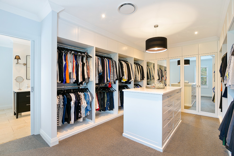 Imagen de vestidor unisex contemporáneo grande con armarios con paneles empotrados, puertas de armario blancas y moqueta