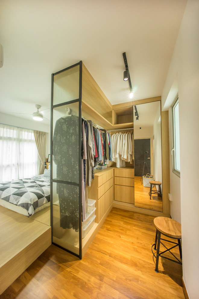 Foto de armario vestidor unisex actual con armarios abiertos, puertas de armario de madera clara y suelo de madera en tonos medios