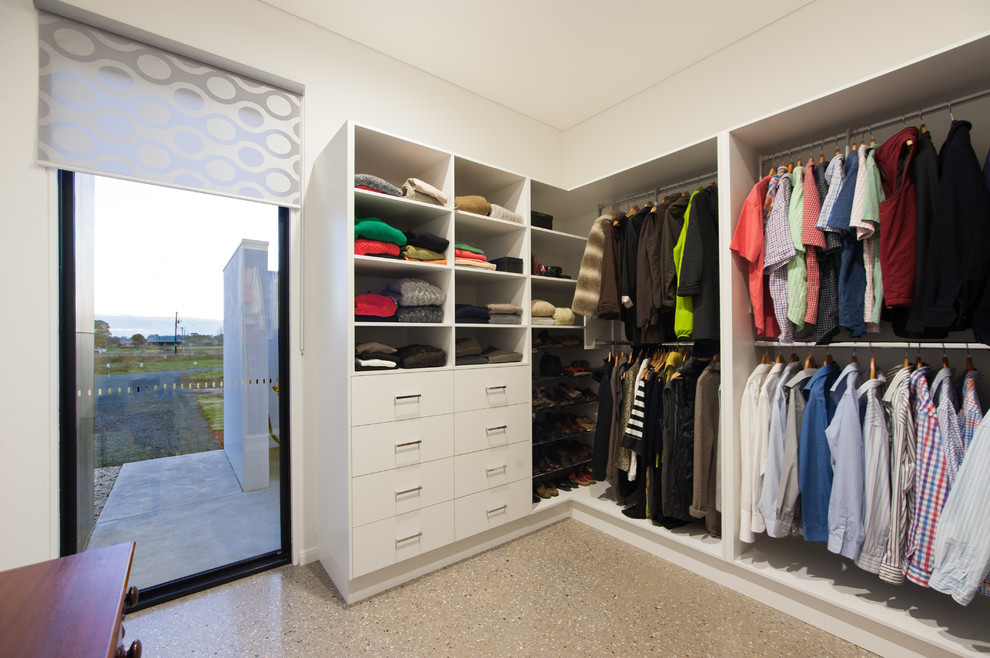 Foto de armario vestidor unisex minimalista de tamaño medio con armarios abiertos, puertas de armario blancas y suelo de cemento
