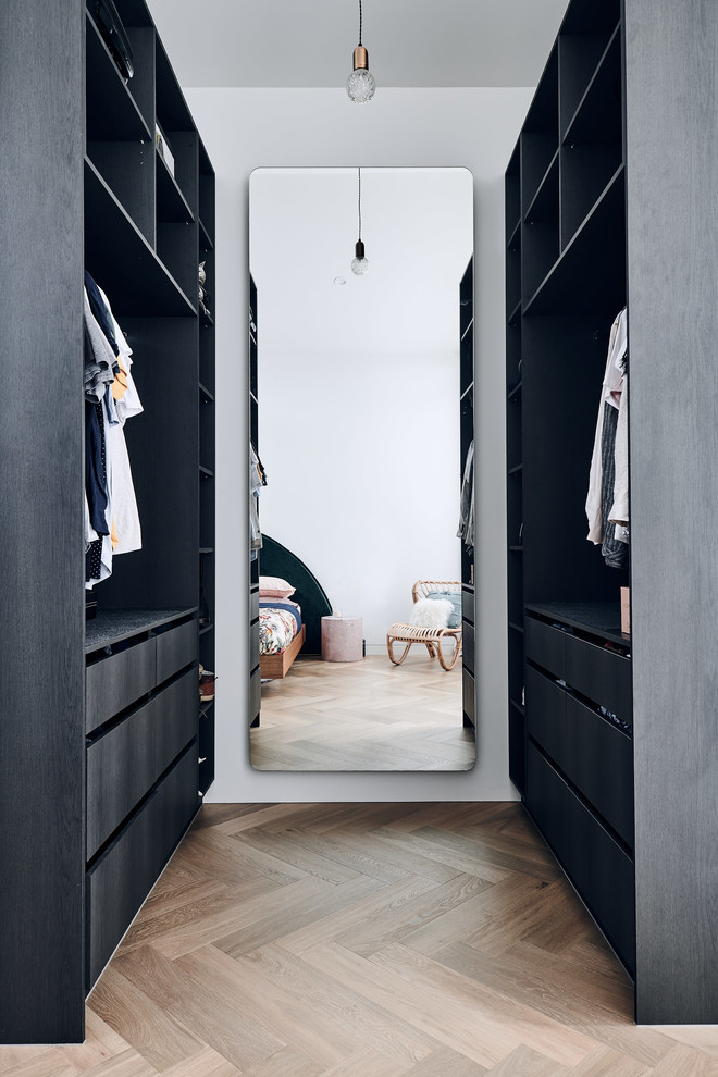 Moderner Begehbarer Kleiderschrank mit flächenbündigen Schrankfronten, schwarzen Schränken, braunem Holzboden und braunem Boden in Melbourne